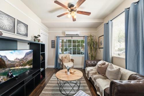 a living room with a couch and a tv at Perfect Location Walking Distance to Everything in Sacramento
