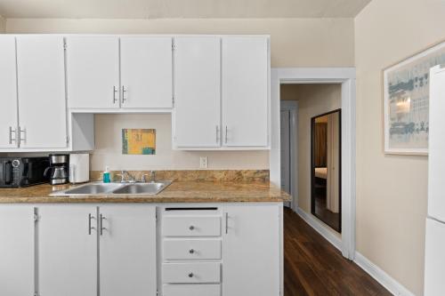 a kitchen with white cabinets and a sink at Perfect Location Walking Distance to Everything in Sacramento