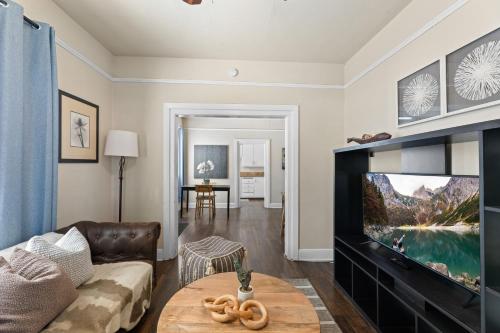 a living room with a couch and a tv at Perfect Location Walking Distance to Everything in Sacramento