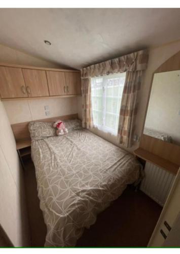 a small bedroom with a bed and a window at OV19- Wind in the willow summer house in Heysham
