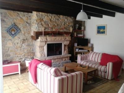 un salon avec deux canapés et une cheminée en pierre dans l'établissement KERMARIUs, à Plougastel-Daoulas