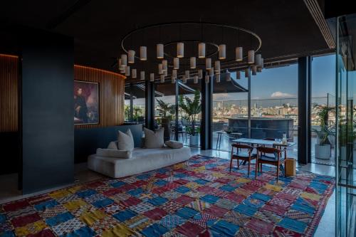 a living room with a chandelier and a table at Memmo Príncipe Real, a Member of Design Hotels in Lisbon
