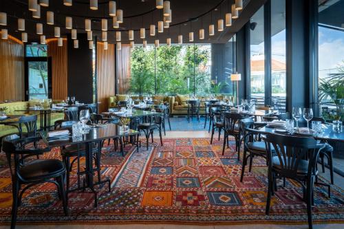 a restaurant with tables and chairs on a rug at Memmo Príncipe Real, a Member of Design Hotels in Lisbon