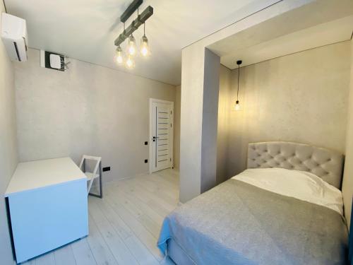 a small bedroom with a bed and a desk at Золотий Бугаз корп5 апарт3 in Odesa