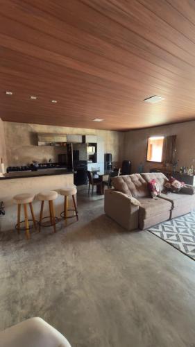 a living room with a couch and tables and a kitchen at Rancho Helena in Maceió