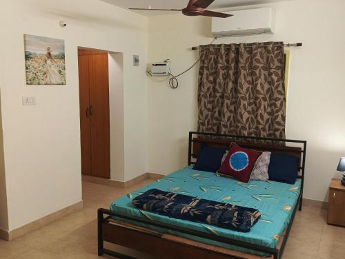 a small bedroom with a bed with blue sheets at Comfort Zone in Chennai