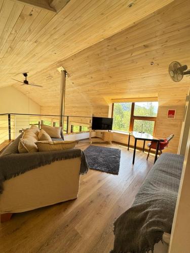 a large wooden room with a bed and a table at Refugio entre Montañas - Malalcahuello in Malalcahuello