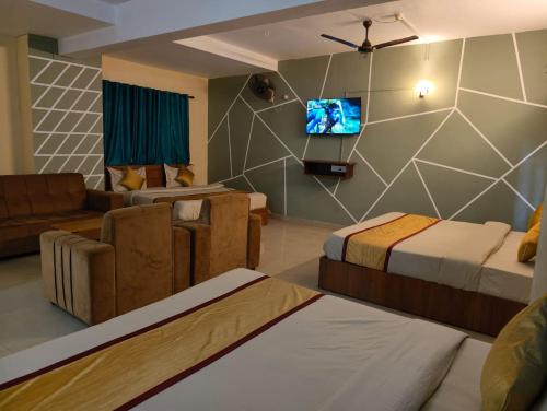 a hotel room with two beds and a flat screen tv at Hill View Residency in Kalpetta