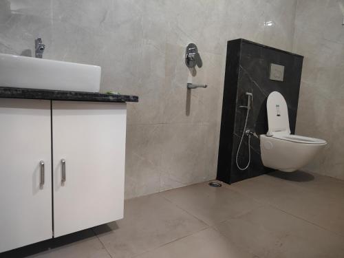 a bathroom with a toilet and a sink and a phone at Greenland Premium Hotel in Bhubaneshwar