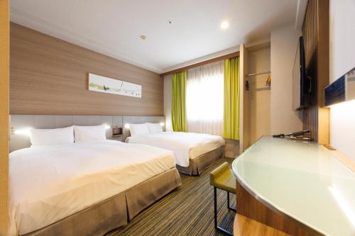 a hotel room with two beds and a flat screen tv at Hotel Sardonyx Ueno in Tokyo