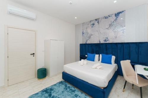 a blue and white bedroom with a bed and a desk at Guest House Partenope in Naples