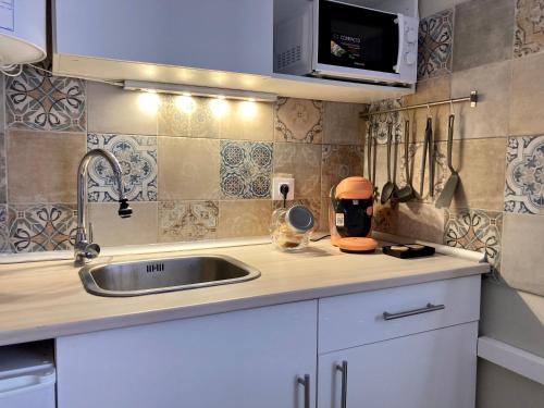 a kitchen with a sink and a microwave at Sea Breeze Alojamientos in Barbate
