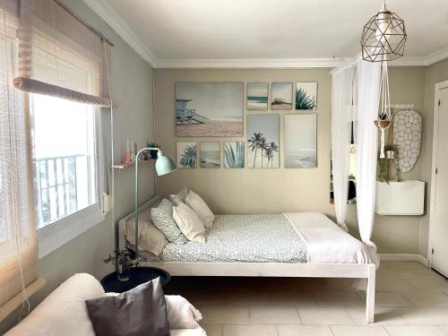 a bedroom with a bed and a window and a couch at Sea Breeze Alojamientos in Barbate