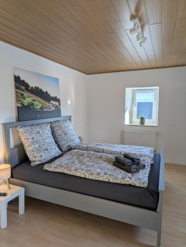 a bedroom with a large bed with a wooden ceiling at Drive & Dream Nürburgring in Drees