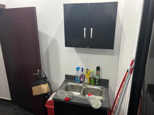 a kitchen sink with a black cabinet above it at Therese Home in Ngor