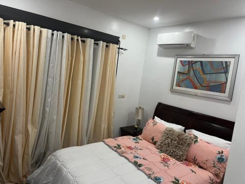 a bedroom with a bed with pink and white at Therese Home in Ngor