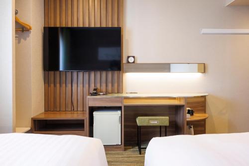 a hotel room with a flat screen tv and a desk at Hotel Sardonyx Ueno in Tokyo