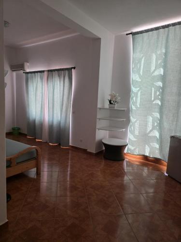 a living room with two windows and a tiled floor at Aparthotel Santa Maria Beach in Santa Maria