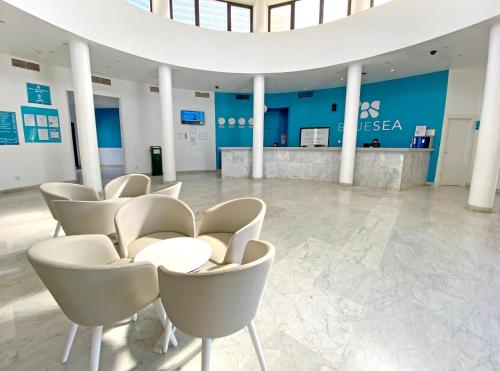 a lobby with white chairs and a reception desk at BLUESEA Costa Teguise Gardens in Costa Teguise
