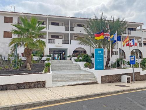 a building with flags and stairs in front of it at BLUESEA Apartamentos Callao Garden in Callao Salvaje