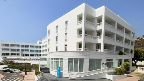 a white building with balconies and a parking lot at BLUESEA Lagos de Cesar in Puerto de Santiago