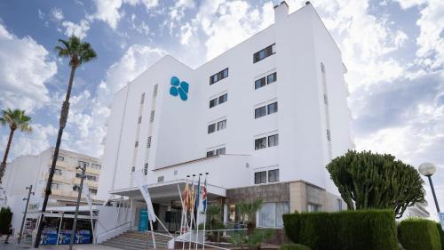 a white building with a blue sign on it at BLUESEA Anba Romaní in Cala Millor