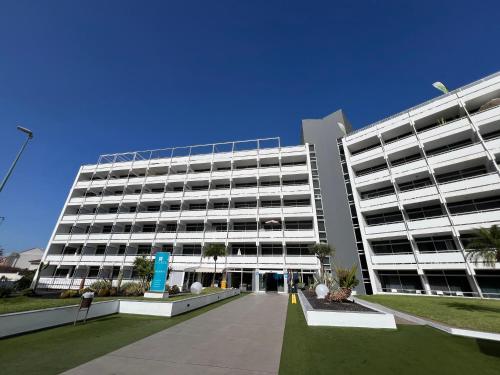 a large white building with a courtyard in front of it at BLUESEA Interpalace in Puerto de la Cruz