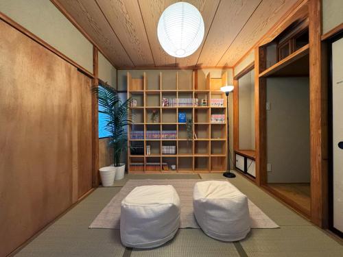 a living room with two white ottomans in a room at SAUNA HOUSE Yutagawa in Tsuruoka