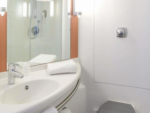 a white bathroom with a sink and a toilet at ibis Albert Pays de Somme in Albert