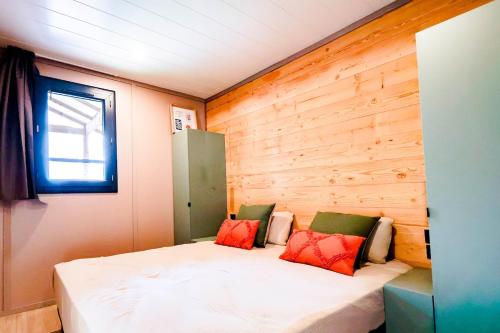 a bed in a room with a wooden wall at Prestige Chalet 50 in Rivières