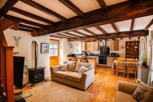 a living room with a couch and a stove at The Granary at Little Howle Farm in Ross on Wye
