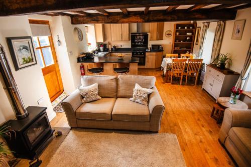 a living room with a couch and a kitchen at The Granary at Little Howle Farm in Ross on Wye