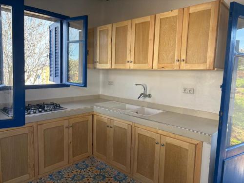 a kitchen with wooden cabinets and a sink at Darnamed in Nador
