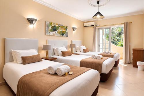 a bedroom with three beds with stuffed animals on them at Villa Panoramica by Algarve Holidays in Estói