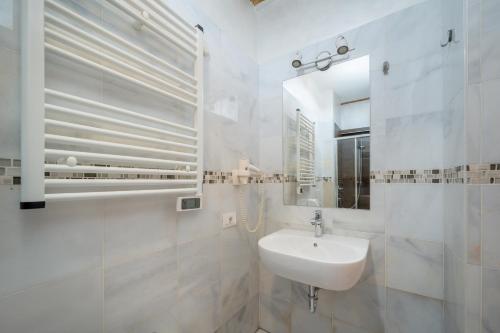 a white bathroom with a sink and a mirror at Gardar Studio Fox in Bolzano