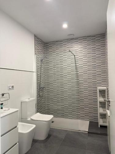 a white bathroom with a toilet and a shower at Orballo in Vilagarcia de Arousa