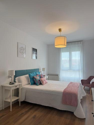a bedroom with a large bed and a lamp at Orballo in Vilagarcia de Arousa