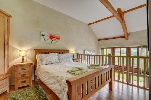 a bedroom with a bed and a balcony with windows at 1 Bed in Tiverton oc-work in Bampton