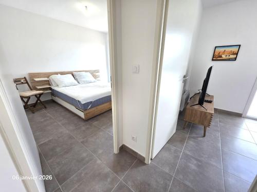 a bedroom with a bed and a table and a mirror at Spacieux appartement dans résidence avec piscine in Bormes-les-Mimosas