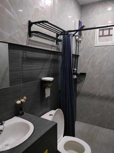 a bathroom with a toilet and a sink at Kia Ora Villa Staycation in Los Baños