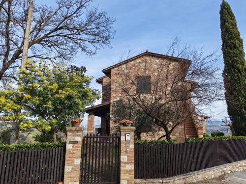 a brick house with a fence in front of it at Il Casale del Priore in Todi