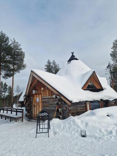 eine Blockhütte mit schneebedecktem Dach in der Unterkunft Suomunkutsu 2 in Suomutunturi