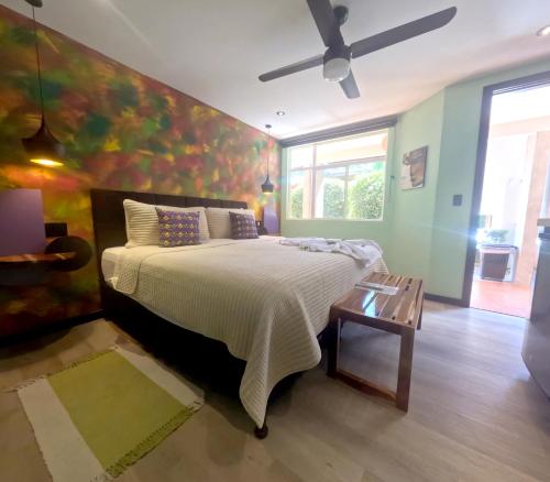 a bedroom with a bed with a painting on the wall at Parti Gras Hotel & Villas en Playa Potrero in Potrero