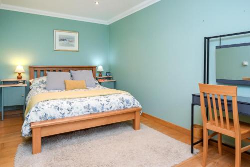 a bedroom with blue walls and a bed and a chair at 2 Bed in Reef oc-r30133 in Uig