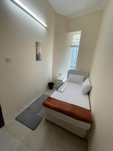 a small bedroom with a bed and a window at Deira Guest house by PHM in Dubai