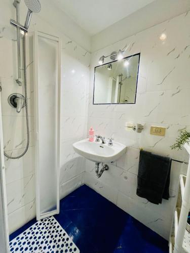 a white bathroom with a sink and a mirror at Dolce casa in Lucca