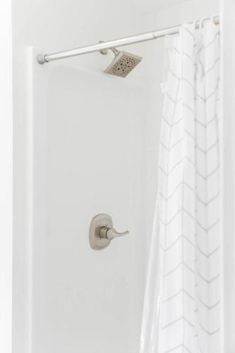 a shower with a white shower curtain and a shower head at Hidden Gem Lake House 3BR, 2.5BA in Holbrook