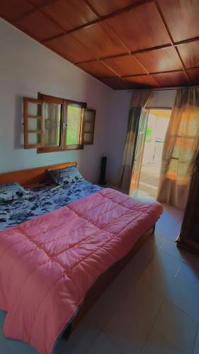 una camera da letto con un letto grande con un piumone rosso di Villa Baabel a Poponguine