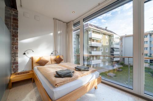 a bedroom with a bed and a large window at Gardar in Bolzano