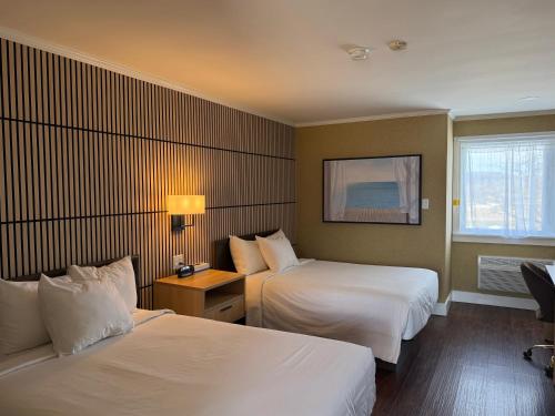 a hotel room with two beds and a window at Annapolis Royal Inn & Suites in Annapolis Royal